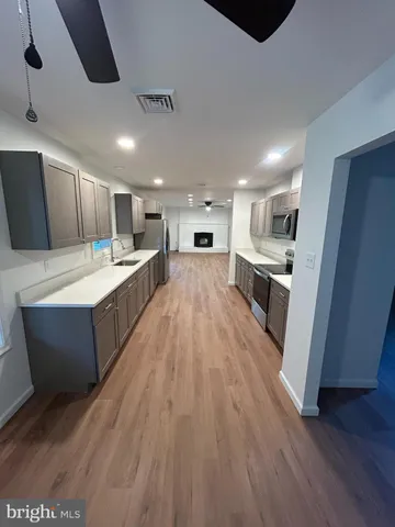 a large kitchen with a large counter top appliances and cabinets