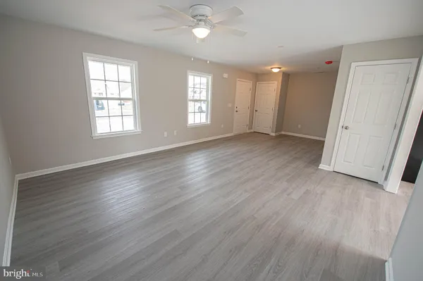 an empty room with wooden floor and entrance