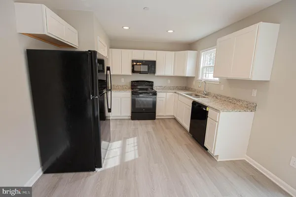 a kitchen with a sink stove top oven and refrigerator