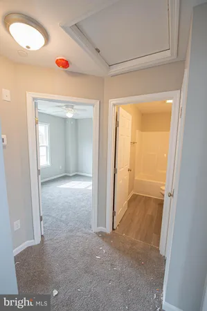 an empty room with a window and ceiling fan