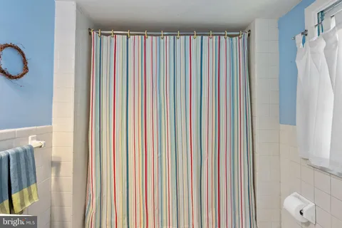 a view of a bedroom with a window and a shower