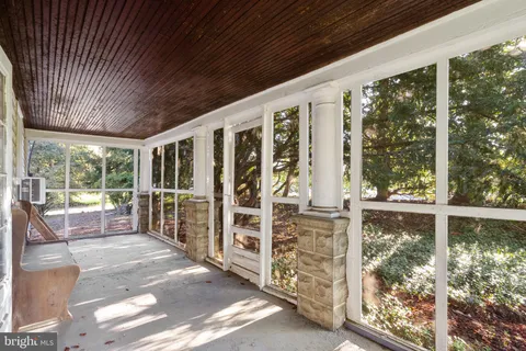 a view of a porch with furniture and floor to ceiling window