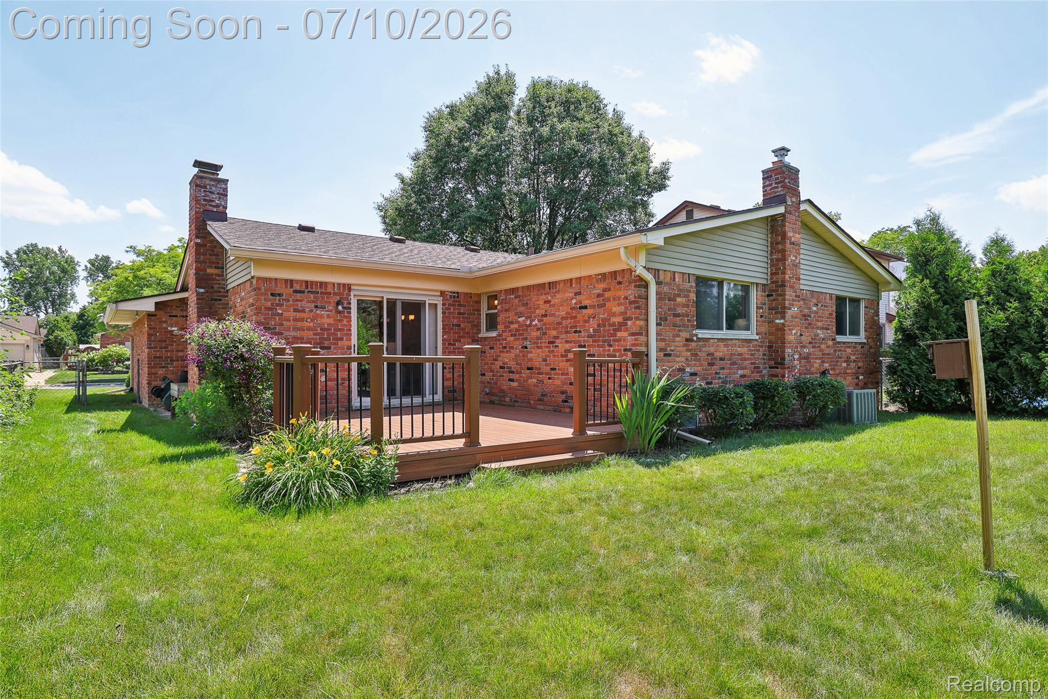42698 Keystone Canton, MI 48187 - Photo 31 of 33 Red brick exterior with light-colored siding, featuring two prominent brick chimneys