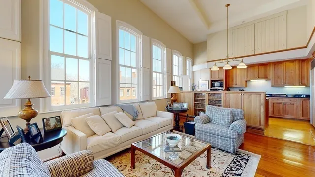 a living room with furniture a flat screen tv a rug and a window