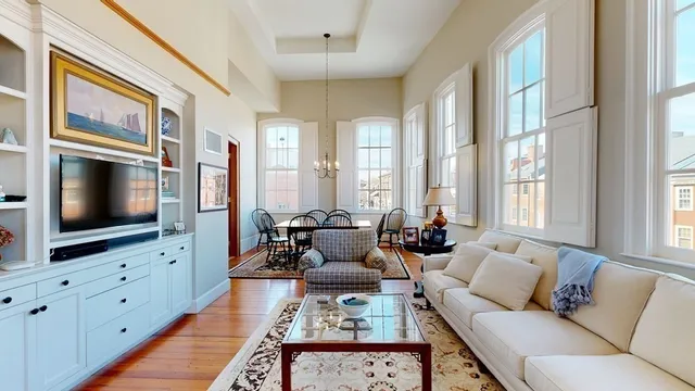 a dining room with furniture a chandelier and wooden floor