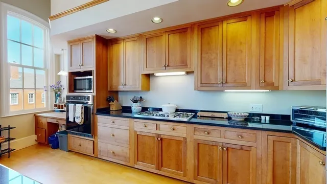 a kitchen with stove a sink and cabinets