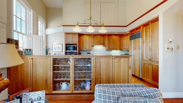 a living room with furniture a flat screen tv and a floor to ceiling window