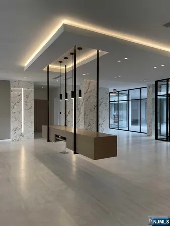 an empty room with large windows and chandelier
