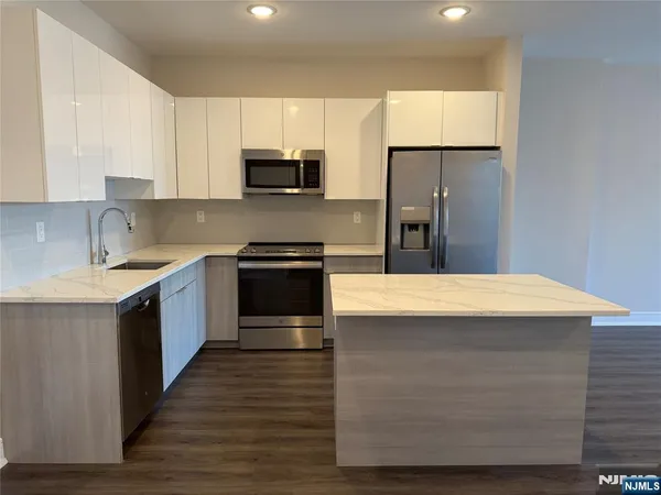 a kitchen with stainless steel appliances kitchen island a cabinets and wooden floor