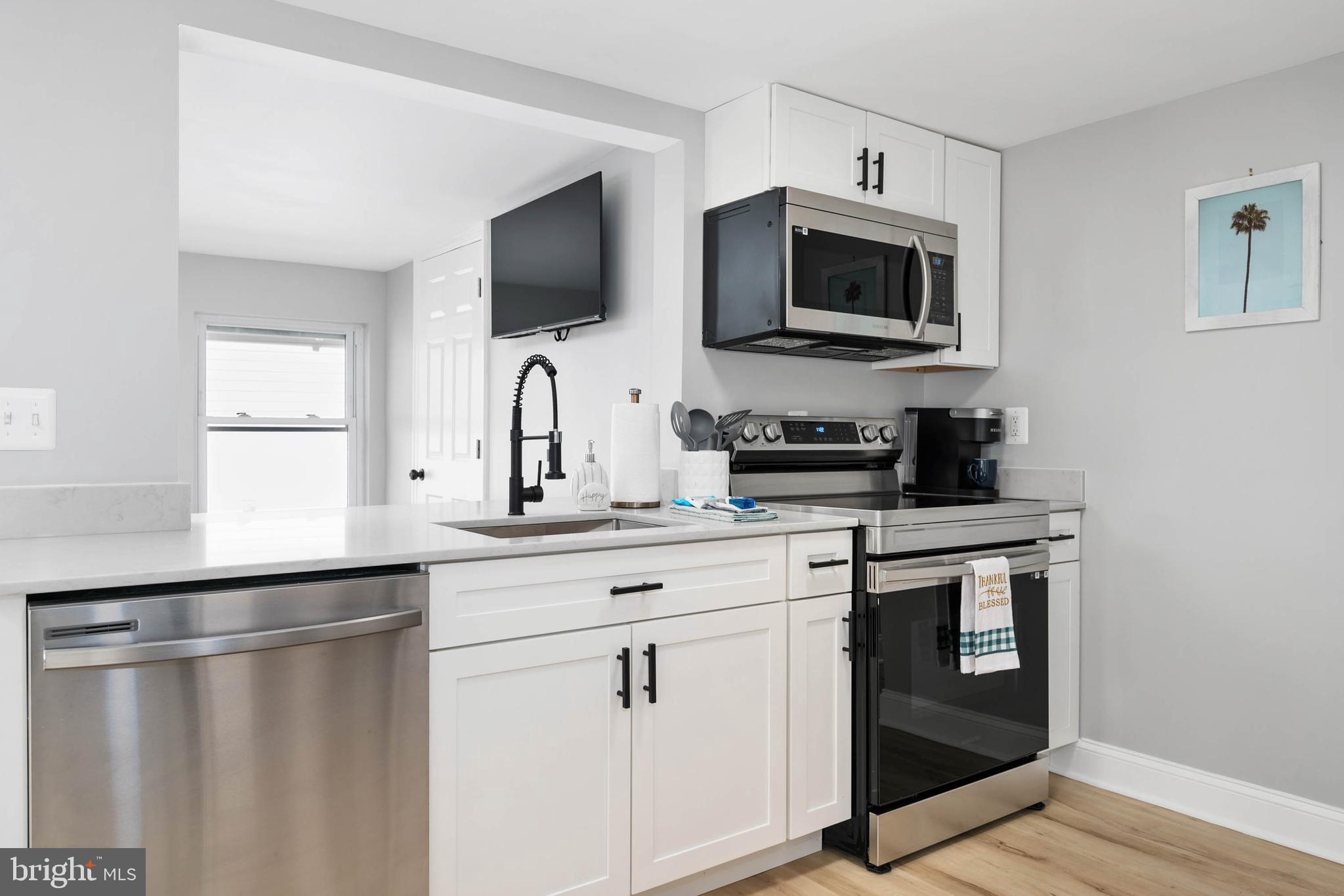 126 Skipjack Circle Berlin, MD 21811 - Photo 13 of 42 a kitchen with stainless steel appliances a stove microwave and sink