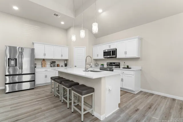 a kitchen with stainless steel appliances granite countertop a sink and a stove