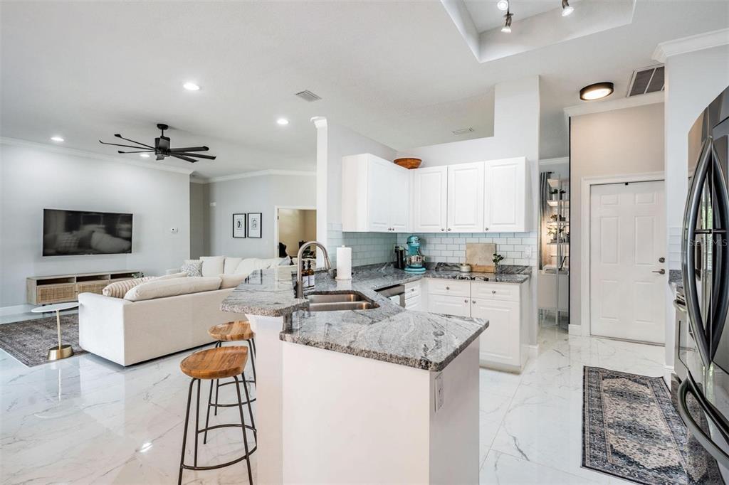 28335 Glade Fern Court Wesley Chapel, FL 33543 - Photo 15 of 44 a view of a kitchen with kitchen island stainless steel appliances refrigerator stove dining table and chairs