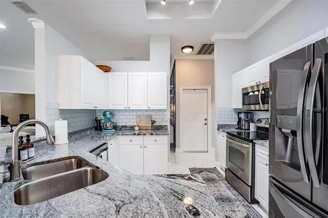 a kitchen with a sink cabinets and stainless steel appliances