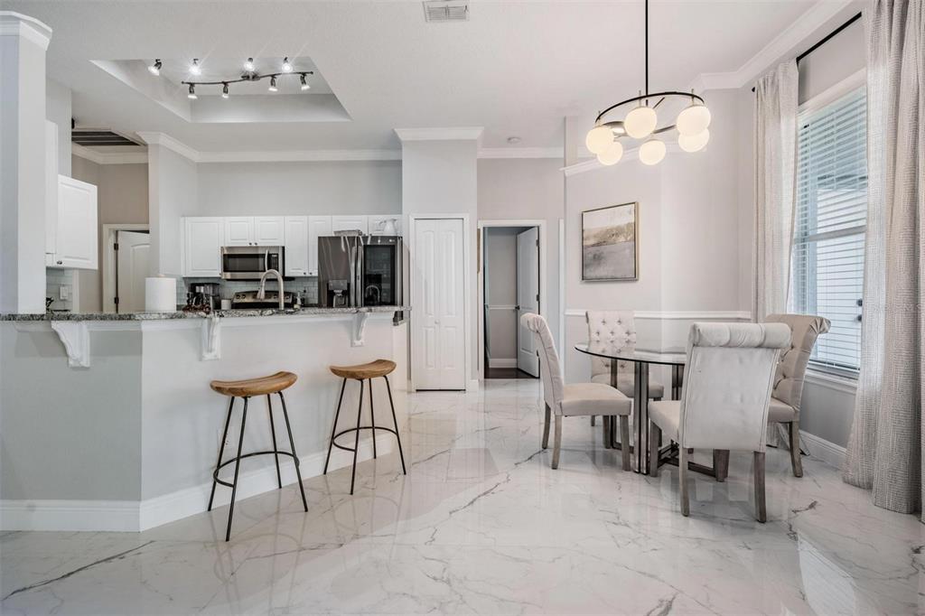 28335 Glade Fern Court Wesley Chapel, FL 33543 - Photo 20 of 44 a dining room filled chandelier and kitchen view