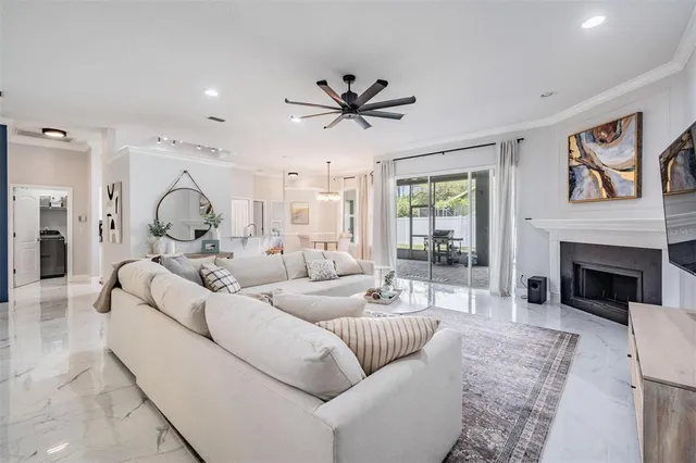 a living room with furniture a fireplace and a large window