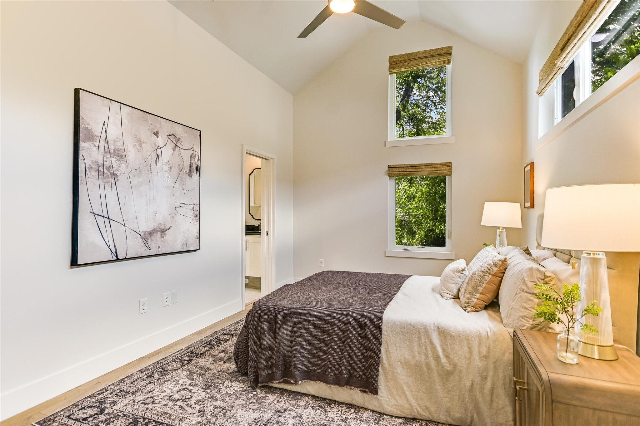 1605 Hether Street Austin, TX 78704 - Photo 15 of 26 Vaulted ceiling room with multiple high windows, wood-finish flooring, and a ceiling fan