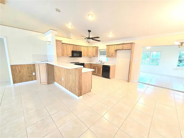 a large white kitchen with a stove a refrigerator a sink and a counter top space