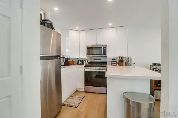 a kitchen with white cabinets and stainless steel appliances