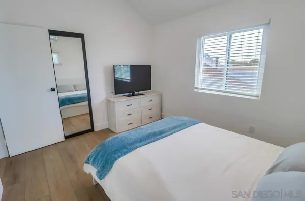 a bedroom with a bed and a flat screen tv