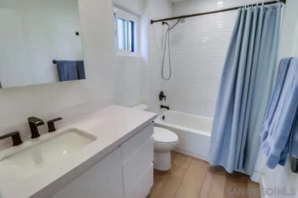 a bathroom with a sink a mirror a toilet and bathtub