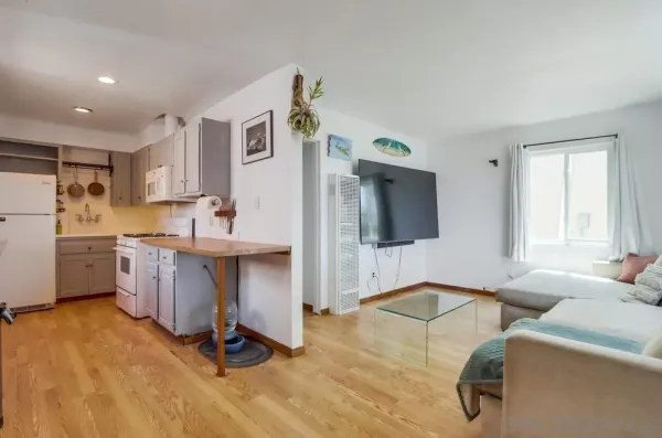 a living room with furniture and a kitchen