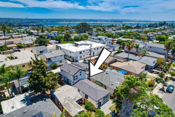 an aerial view of a house with a yard and a large tree