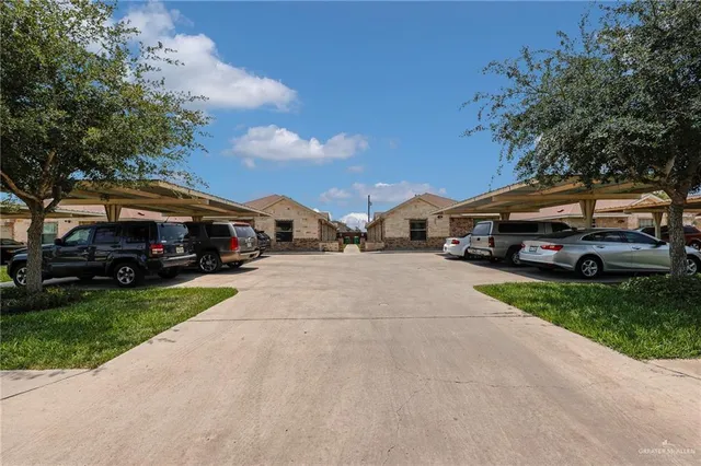 a car parked in front of a house next to a yard