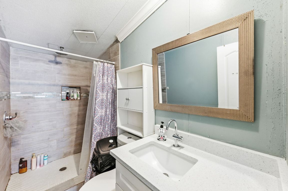 1485 Pettytown Road Dale, TX 78616 - Photo 21 of 36 a bathroom with a sink mirror toilet and shower