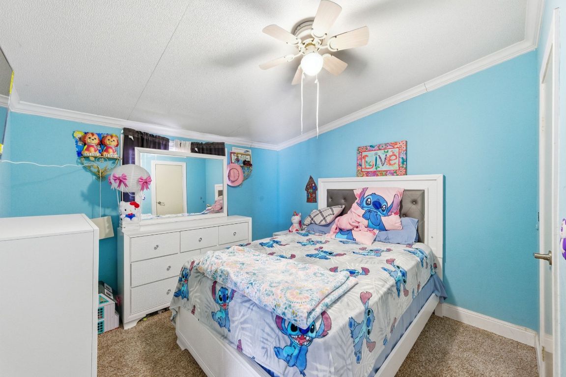 1485 Pettytown Road Dale, TX 78616 - Photo 22 of 36 a bedroom with a bed and a chandelier