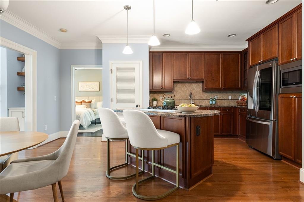825 Highland Lane Northeast, Unit 1112 Atlanta, GA 30306 - Photo 13 of 39 a kitchen with stainless steel appliances granite countertop a refrigerator a stove top oven a sink dishwasher and white cabinets with wooden floor