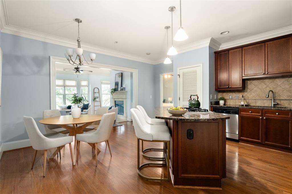 825 Highland Lane Northeast, Unit 1112 Atlanta, GA 30306 - Photo 14 of 39 a kitchen with stainless steel appliances granite countertop a stove a sink dishwasher a dining table and chairs with wooden floor