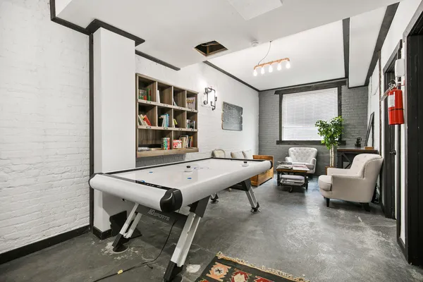 a living room with furniture pool table and a large window