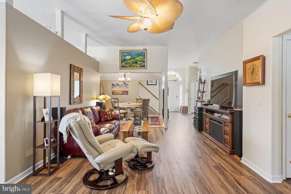 a view of a livingroom with furniture a ceiling fan and wooden floor