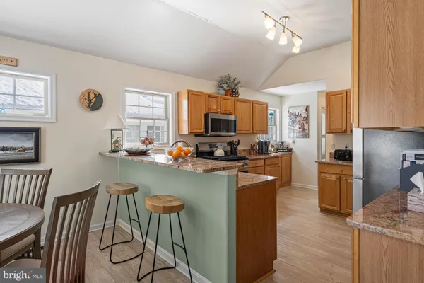 a kitchen with sink a refrigerator and chairs