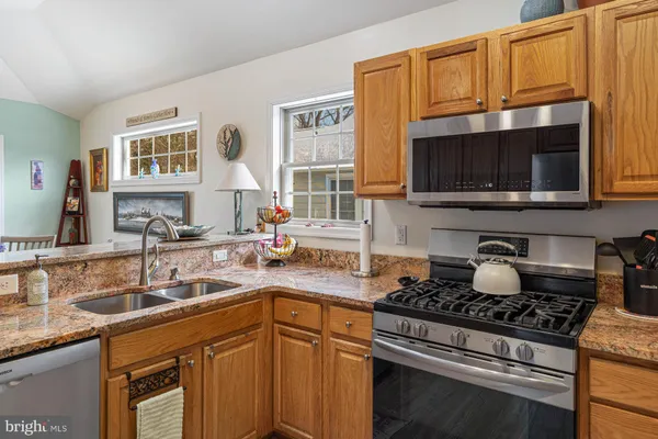 a kitchen with stainless steel appliances granite countertop a stove microwave and sink