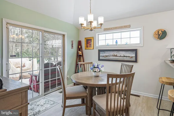 a view of a dining room with furniture a chandelier and wooden floor