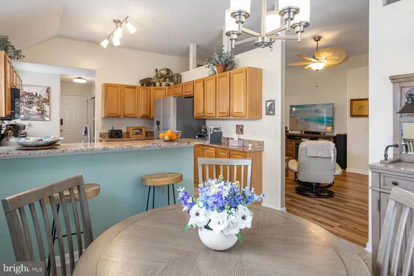 a kitchen with stainless steel appliances a dining table chairs and chandelier