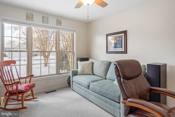 a living room with furniture and a computer on a desk