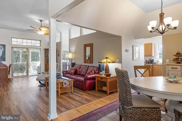 a living room with furniture a large window and a dining table