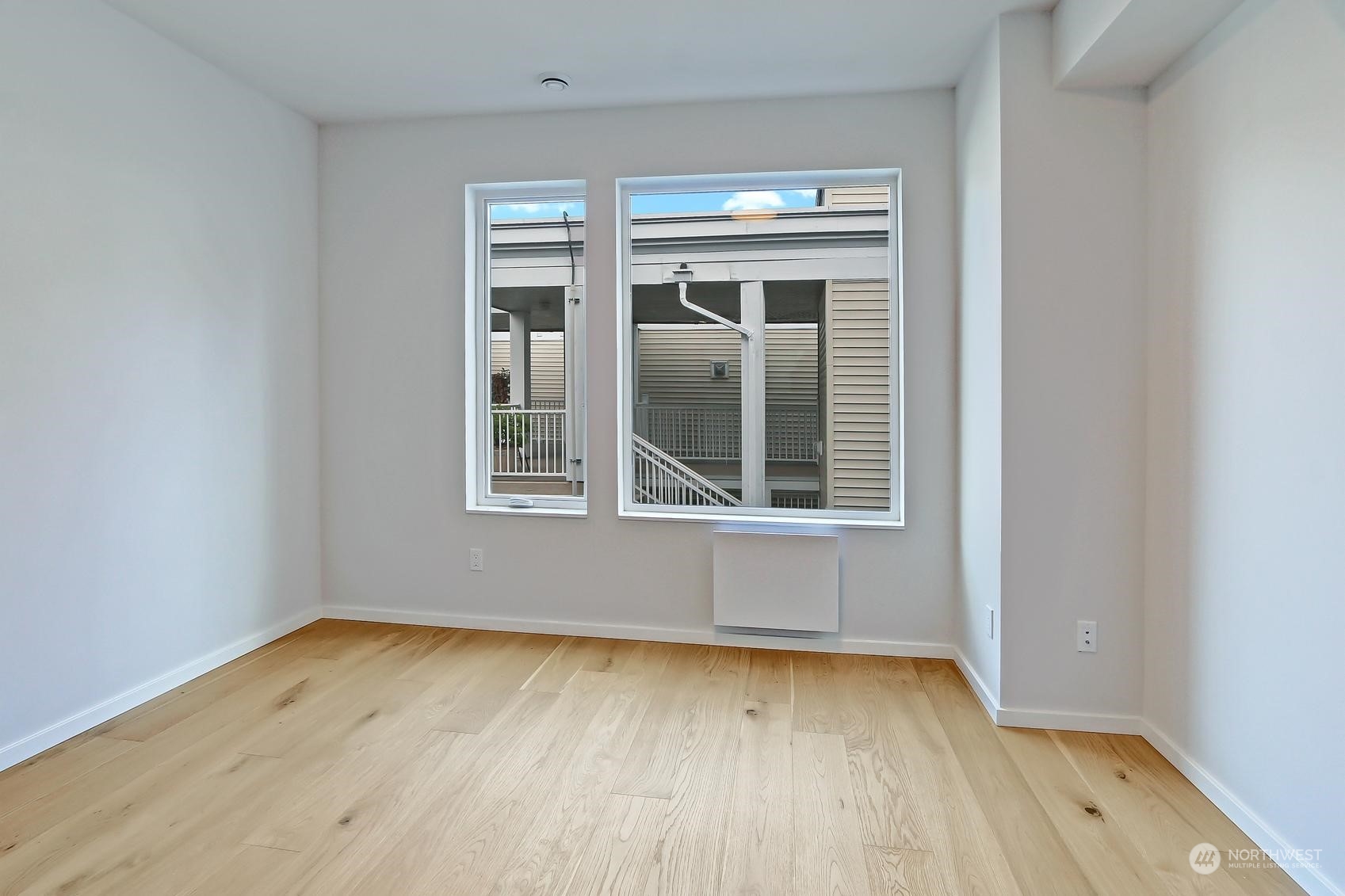 17342 Bothell Way Northeast, Unit H Bothell, WA 98011 - Photo 13 of 19 a view of an empty room with wooden floor and a window