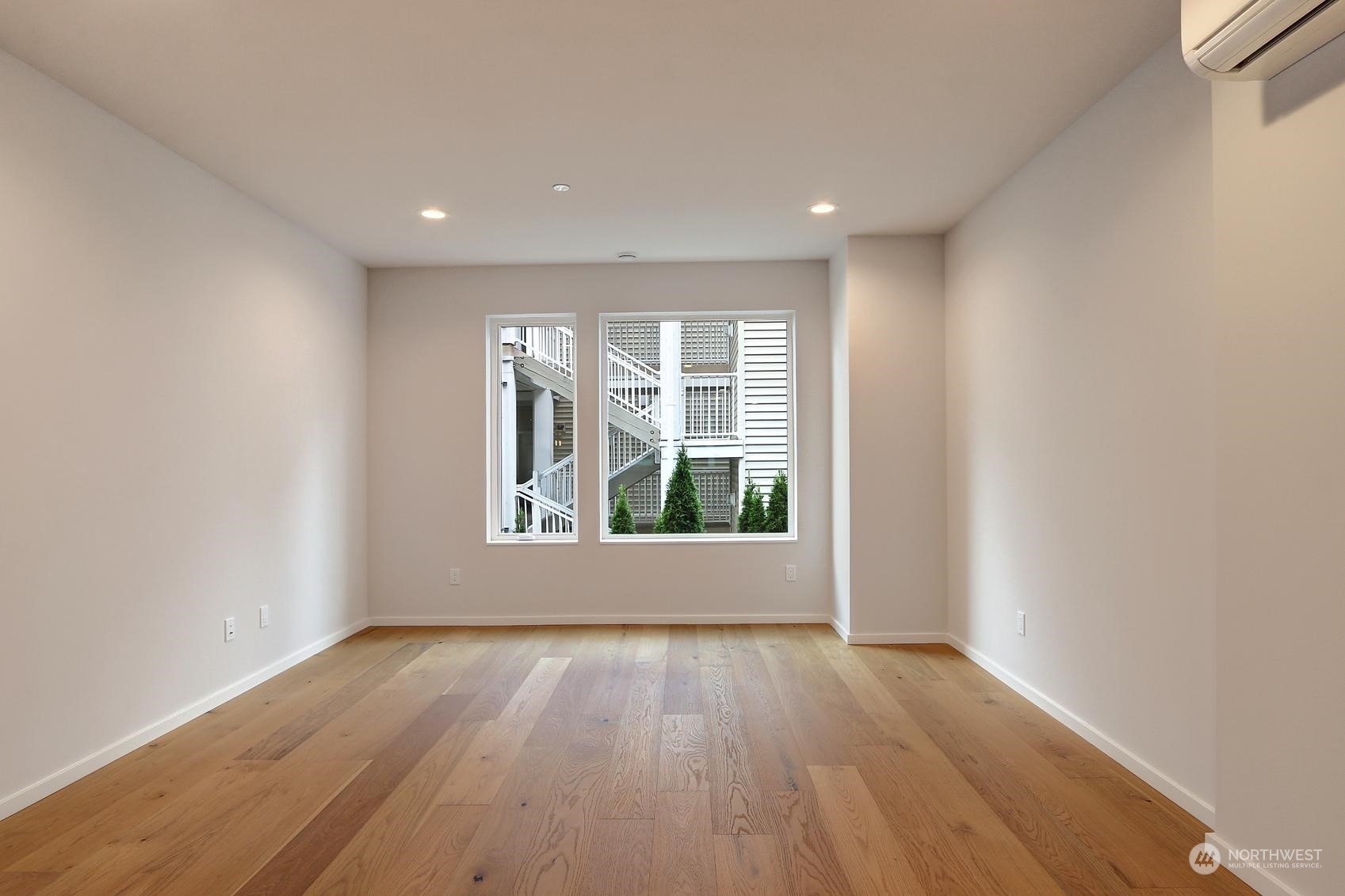 17342 Bothell Way Northeast, Unit H Bothell, WA 98011 - Photo 7 of 19 an empty room with wooden floor and windows