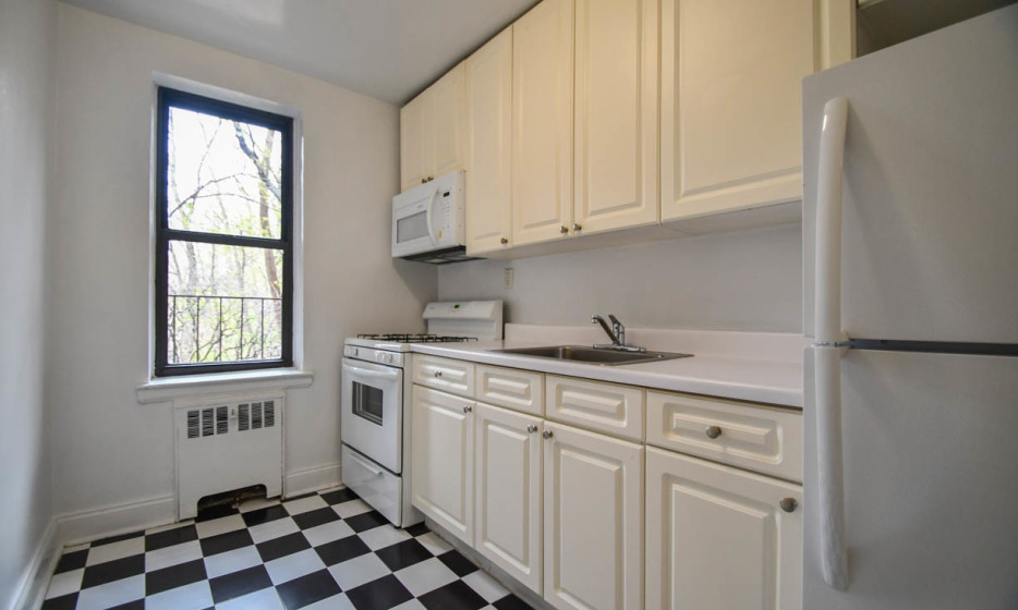 a kitchen with a sink a stove and white cabinets