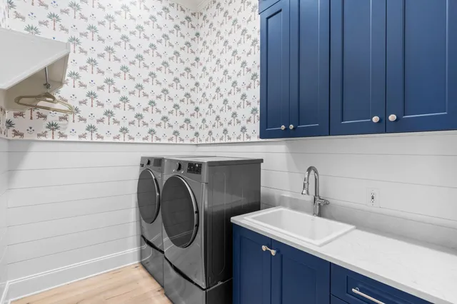 a view of a patio with a table and chairs under an umbrella with large trees
