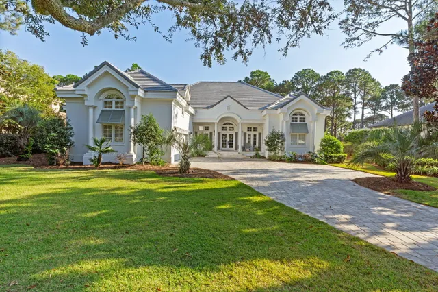 an aerial view of a house with a yard and a large tree