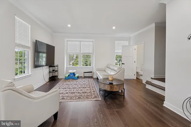 a living room with furniture or wooden floor and a large window