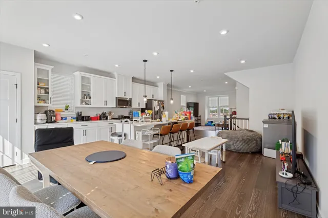 a kitchen with stainless steel appliances kitchen island granite countertop a dining table and chairs with wooden floor