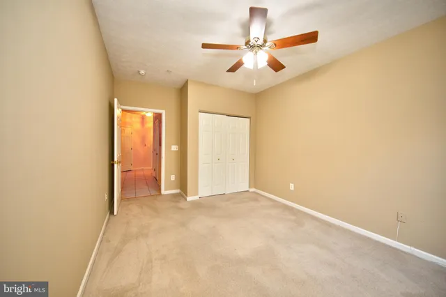 an empty room with a ceiling fan and a window