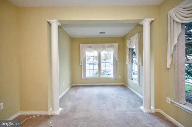 a view of a big room with windows and chandelier