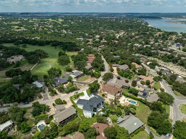 an aerial view of residential houses with outdoor space and trees
