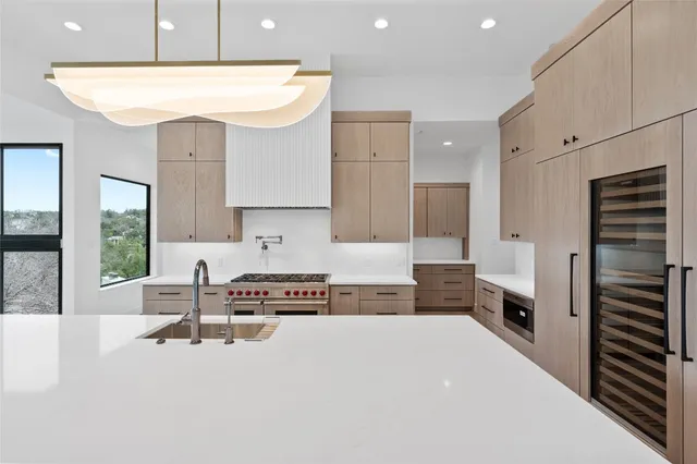 a large white kitchen with a large window